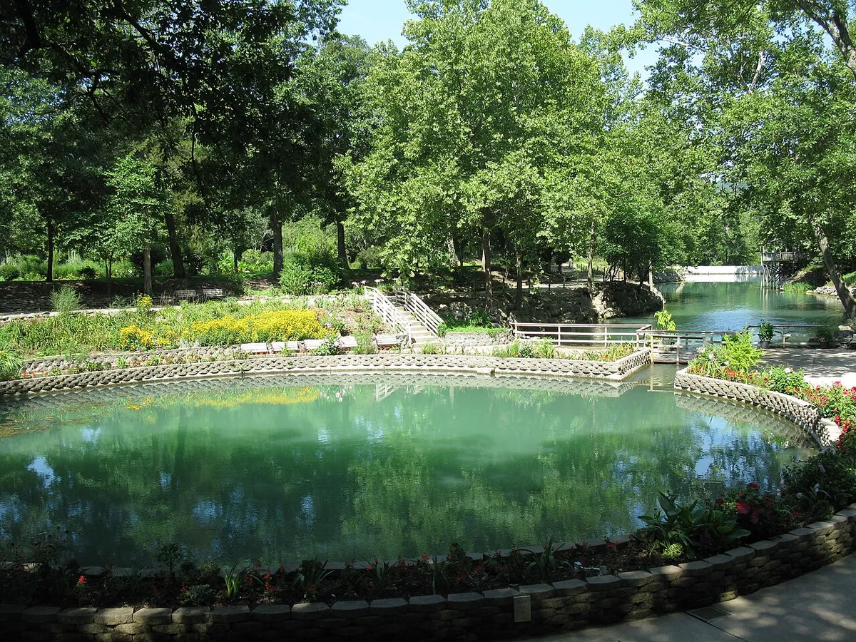 Turquoise spring water, stone walls and wooded gardens at Blue Spring Heritage Center near Eureka Springs