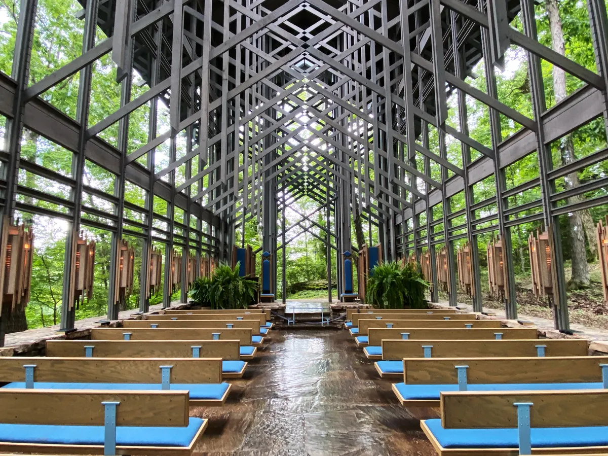 Timber lattice, glass walls and pews inside Thorncrown Chapel near Eureka Springs